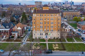 Detroit apartment for rent - A large building with a red roof is in the middle of a residential area.