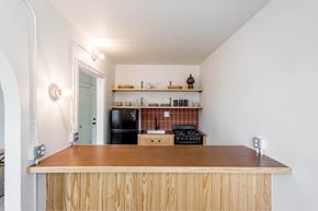 Detroit apartment for rent - A kitchen with a wooden counter and a black fridge.
