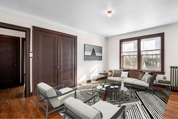 Detroit apartment for rent - A living room with a black and white rug and a grey sofa.