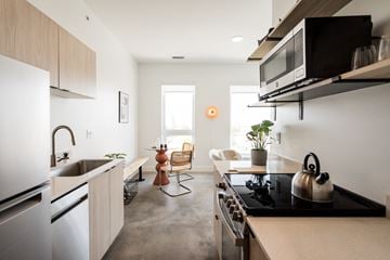 Detroit apartment for rent - A modern kitchen with a black stove top and white appliances.