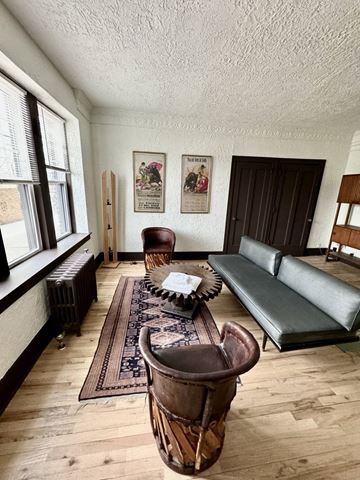 Detoit apartment for rent - A living room with a brown leather couch and a wooden coffee table.