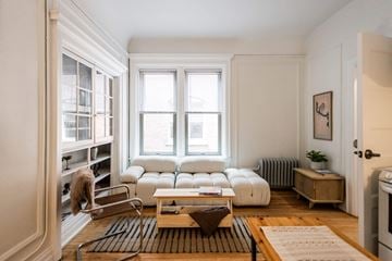 Detroit apartment for rent - A living room with a white sofa set and a wooden coffee table.