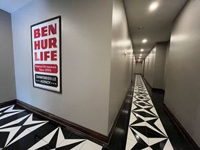 Crawfordsville apartment for rent - A hallway with a Ben Hur Life sign on the wall.