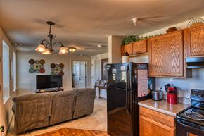 Connersville apartment for rent - A kitchen with a black refrigerator and wooden cabinets.