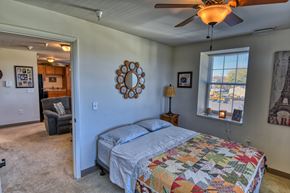 Connersville apartment for rent - A bedroom with a bed, a chair, a ceiling fan, and a window.