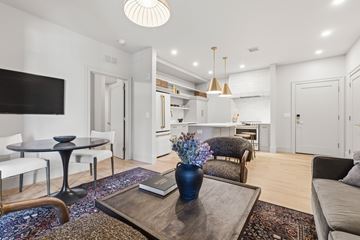 Philadelphia apartment for rent - A modern living room with a black coffee table and a blue vase on it.