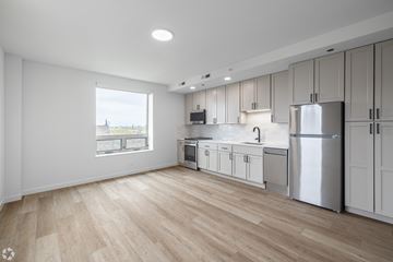 Chicago apartment for rent - A kitchen with white cabinets and a wooden floor.
