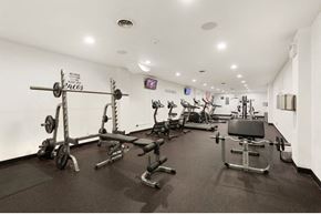 Chicago apartment for rent - A gym with a variety of equipment including a squat rack, bench press, and a treadmill.