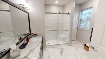 Dual vanities with walk-in tiled showers