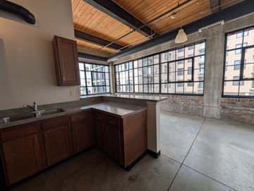 Cleveland apartment for rent - A kitchen with wooden cabinets and a large window.