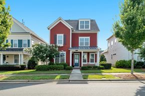 Dallas house for rent - A red house with a white porch and a grey house in the background.