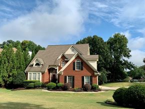 Dallas house for rent - A house with a red brick exterior and a well-manicured lawn.