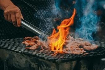 Grilling meat with a flame