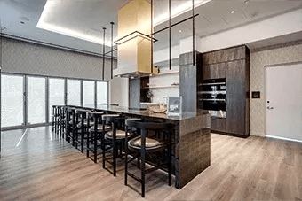 Modern kitchen with a long bar and black chairs
