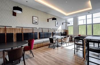 Room with tables and chairs and a long bench