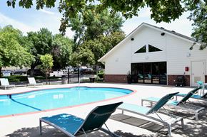 Lavista apartment for rent - A pool with lounge chairs and a white building in the background. at The Pointe, LaVista, Nebraska