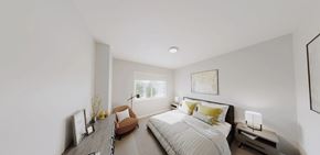 Great Falls apartment for rent - A bedroom with a large bed and a brown chair.
