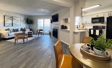 Dallas apartment for rent - A modern living room with a fireplace and a dining table set for two.