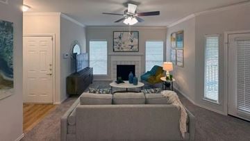 Waxahachie apartment for rent - A living room with a grey couch and a fireplace.