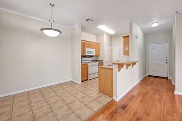 Waco apartment for rent - A kitchen with wooden cabinets and a white door.