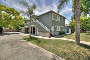 Menlo Park apartment for rent - a green house with a driveway and palm trees