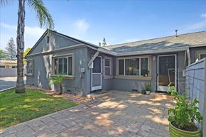Menlo Park apartment for rent - A building with a grey exterior and a patio with a potted plant.
