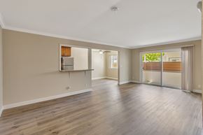 Sunnyvale apartment for rent - A spacious room with wooden flooring and a refrigerator built into the wall.