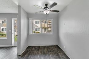 San Jose apartment for rent - A room with a ceiling fan and a window overlooking a building.