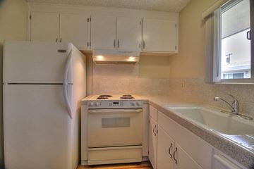 San Jose apartment for rent - a kitchen with white appliances and white cabinets and a sink