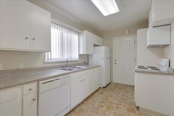 Menlo Park apartment for rent - a kitchen with white cabinets and a sink and a refrigerator