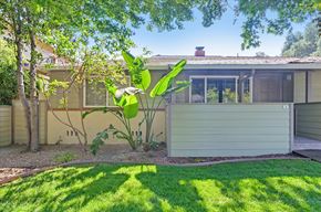 Menlo Park apartment for rent - A house with a green lawn and a tree in front of it.