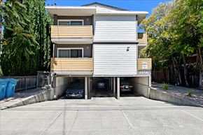 Menlo Park apartment for rent - an apartment building with two cars parked in a parking lot