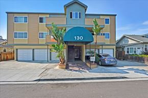 Redwood City apartment for rent - front of a condo building with a car parked in the driveway