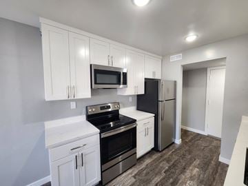 Palo Alto apartment for rent - A kitchen with white cabinets and black appliances.