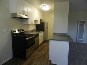 Redwood City apartment for rent - A kitchen with black appliances and white cabinets.