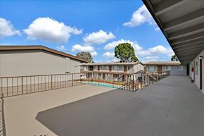 Mountain View apartment for rent - A view of a balcony with a pool and a tree in the background.