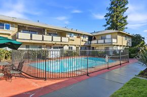Sunnyvale apartment for rent - A pool surrounded by a black fence and chairs.