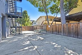 Redwood City apartment for rent - a patio with a fence and a table and a tree