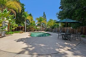 Menlo Park apartment for rent - A backyard with a pool and a table set up for dining.