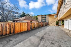 Mountain View apartment for rent - A long driveway with a wooden fence on the left side and a building on the right.