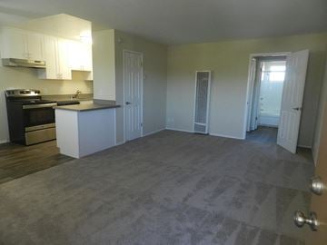 Redwood City apartment for rent - A kitchen with a black stove top oven and white cabinets.