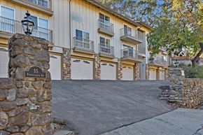 Los Gatos apartment for rent - a driveway with a stone wall in front of a building with white garage doors