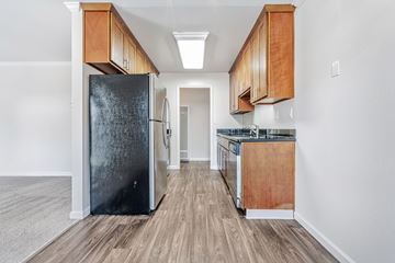 Menlo Park apartment for rent - A kitchen with a black refrigerator and wooden cabinets.
