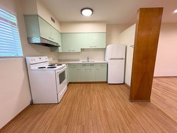 Palo Alto apartment for rent - A kitchen with a white stove and green cabinets.