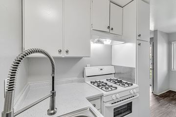 San Jose apartment for rent - A white kitchen with a stove and a hose.
