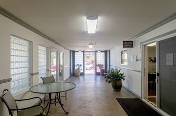Palo Alto apartment for rent - a dining room with a glass table and chairs and a hallway with doors and windows