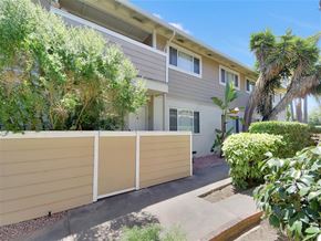 Mountain View apartment for rent - A modern two-story house with a beige fence and a small garden in front.