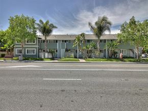 Sunnyvale apartment for rent - A street view of a building with a green facade and trees in front.