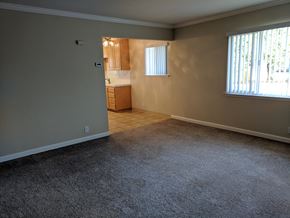 Palo Alto apartment for rent - an empty living room with a kitchen in the background