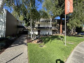 Palo Alto apartment for rent - A building with a sign that says "TEMPORARY" is surrounded by trees and grass.